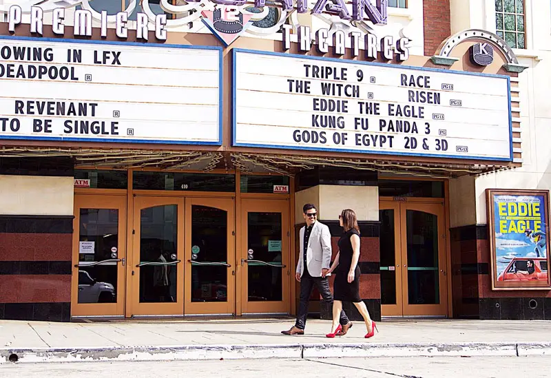 couple élégant marchant devant un cinéma américain