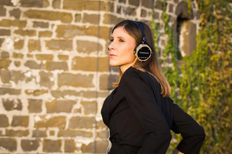 femme qui écoute dehors dans un casque audio noir