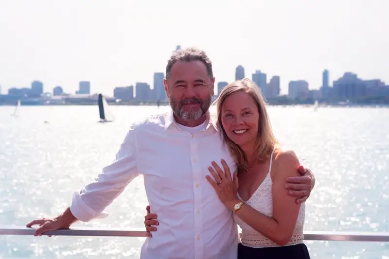 couple amoureux de plus de 50 ans avec en arrière plan une ville en bord de mer