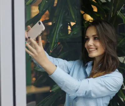 femme brune prend un selfie avec son portable