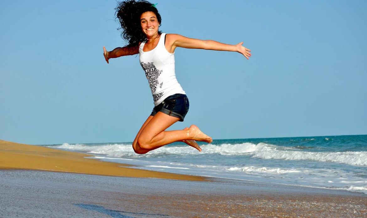 Femme qui saute de joie en bord de mer